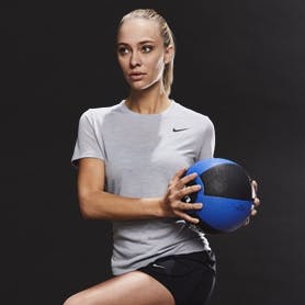 Girl athlete working out with a medicine ball and wearing Nike team gear