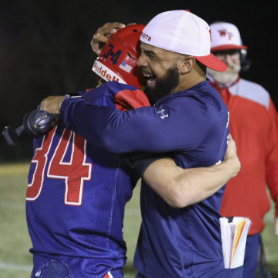Coach hugging a player on the field