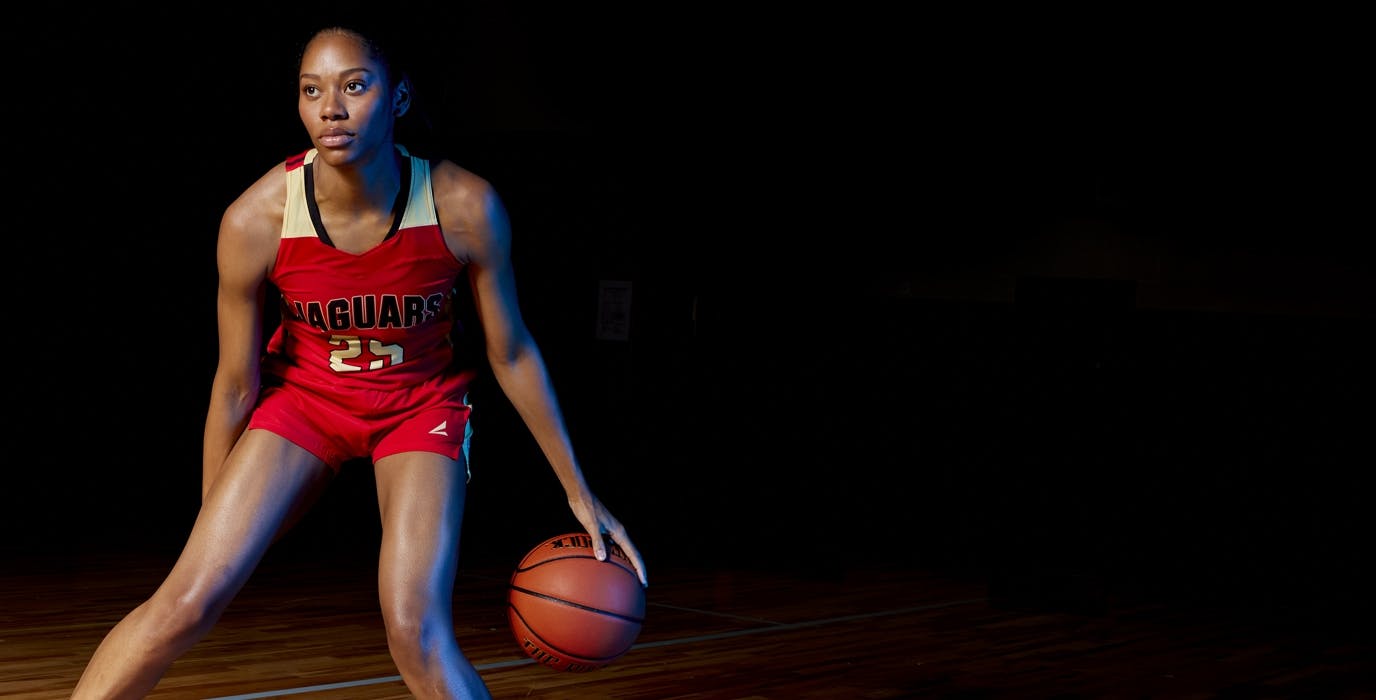 Girl basketball athlete dribbling a basketball and wearing a customized BSN SPORTS Victory uniform