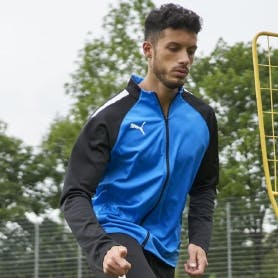 A soccer player practicing and wearing PUMA team gear