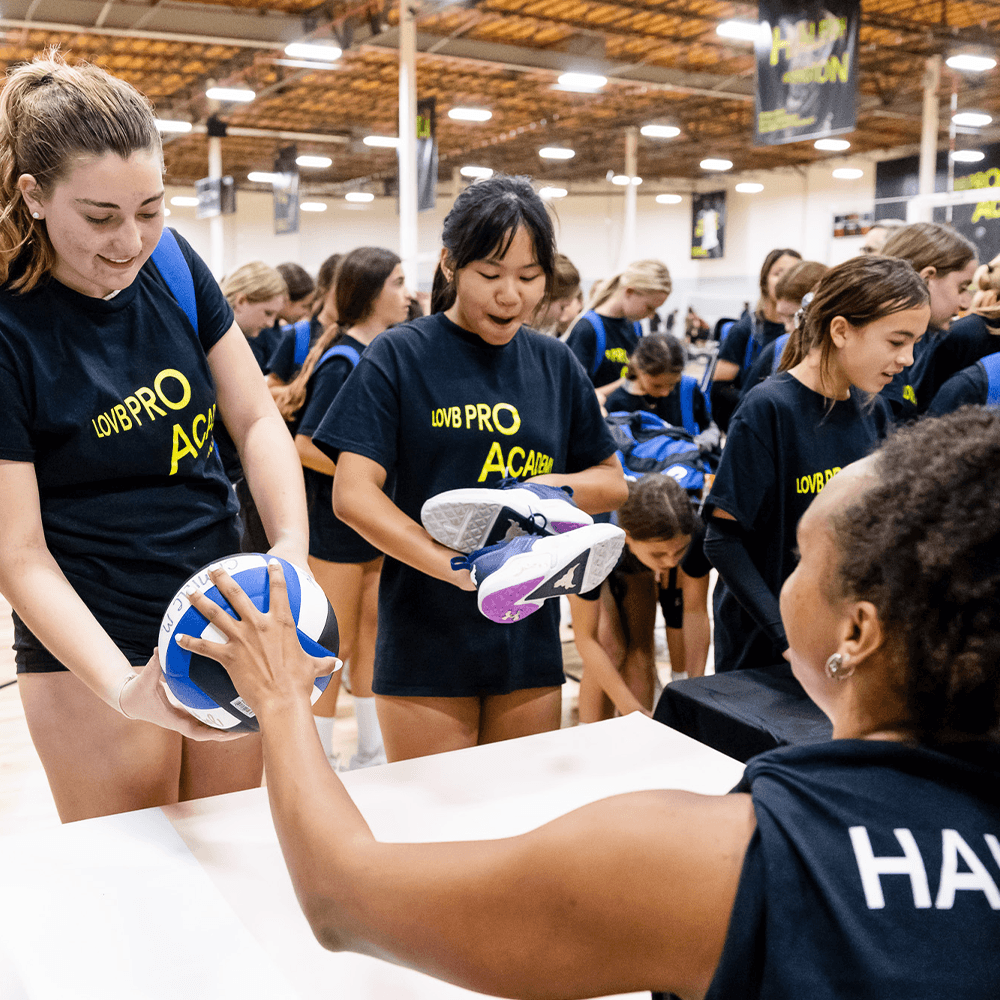 volleyball players lining up to have apparel and gear signed by LOVB pros and partners