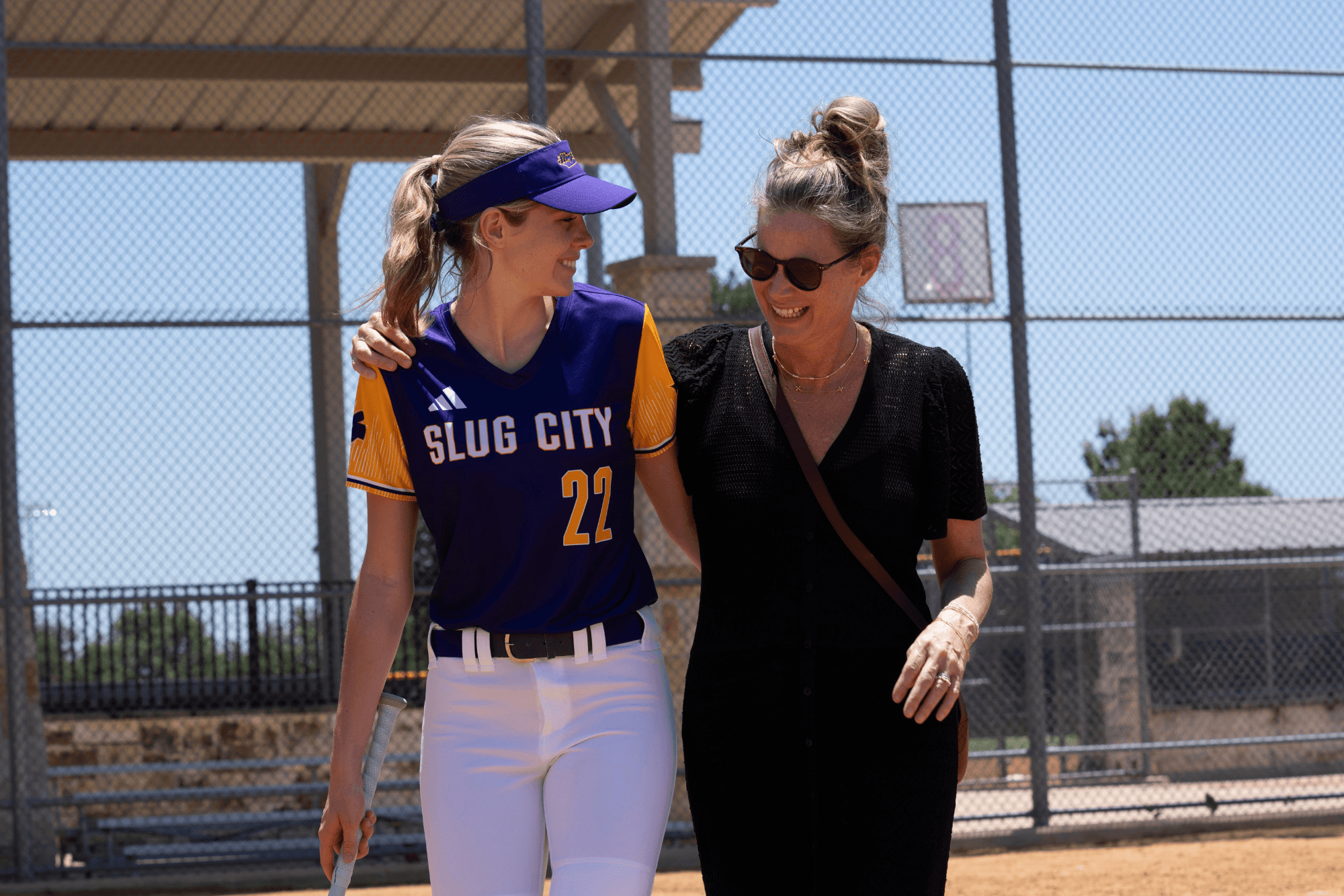a softball player and her mom walking off the softball field together