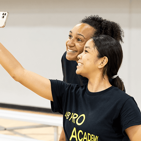 two volleyball players taking a selfie while wearing BSN SPORTS and adidas LOVB apparel